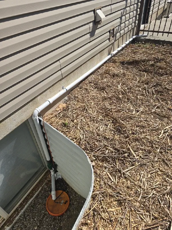 New sump pump discharge piping routed along a North Ogden home's exterior